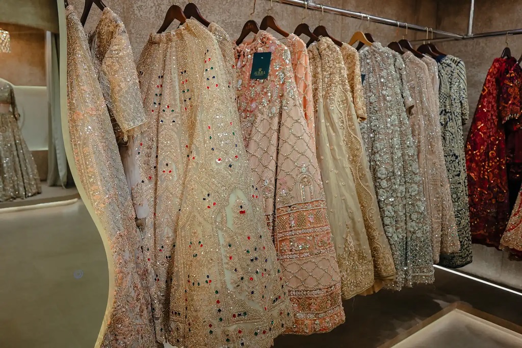 Rails of red and pink bridal lehengas inside the Allura Calicut showroom